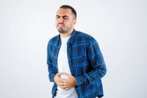 young man having bellyache checked shirt white t shirt looking exhausted 50 scaled 1 - Laparoscopic Surgeon Dr. Digant Pathak